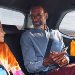 Grandpa and granddaughter talking in backseat of 2026 Toyota Grand Highlander Hybrid