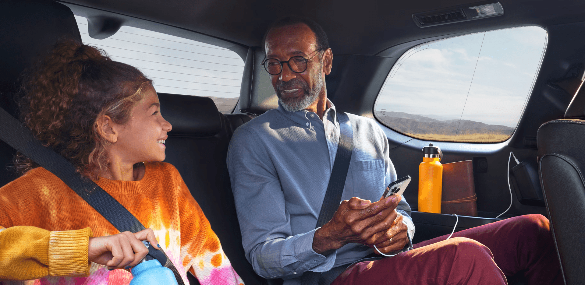 Grandpa and granddaughter talking in backseat of 2026 Toyota Grand Highlander Hybrid