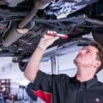 Toyota technician inspecting under car