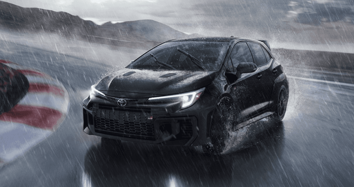 Black 2026 Toyota GR Corolla drifting across a tack in the rain