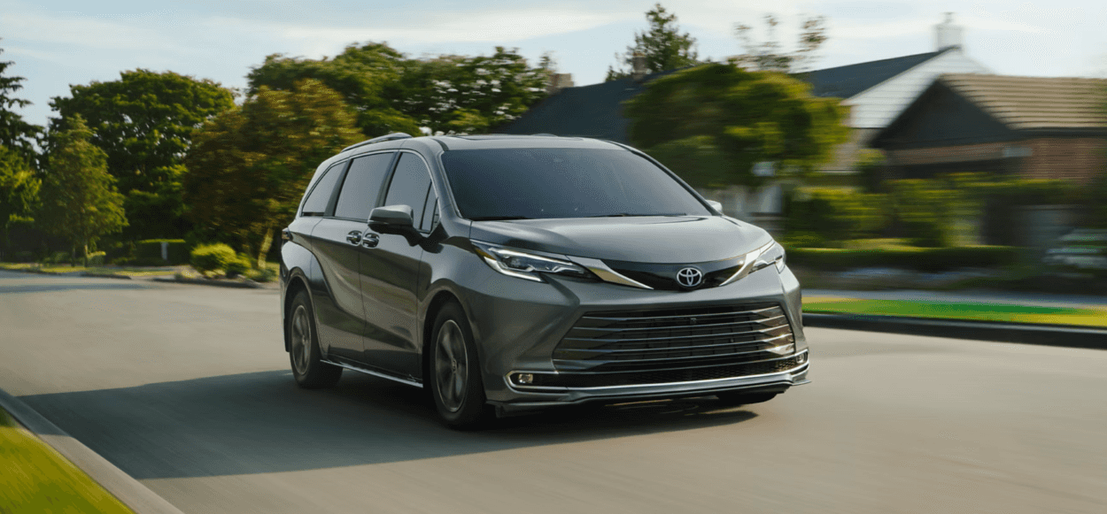 Gray 2026 Toyota Sienna driving down neighborhood road