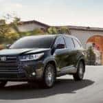 2018 Toyota Highlander driving past homes