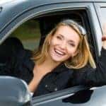 Blonde woman in front seat holding car keys