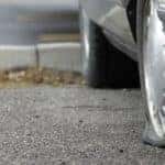 Car parked on a roadway with a flat tire