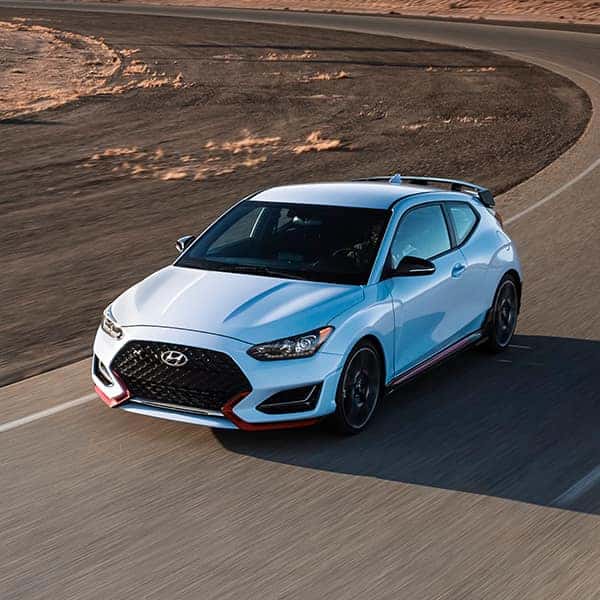 Benefits of Changing Your Hyundai’s Oil at Washington Hyundai in Washington | Light Blue 2021 Veloster Driving Fast on Track
