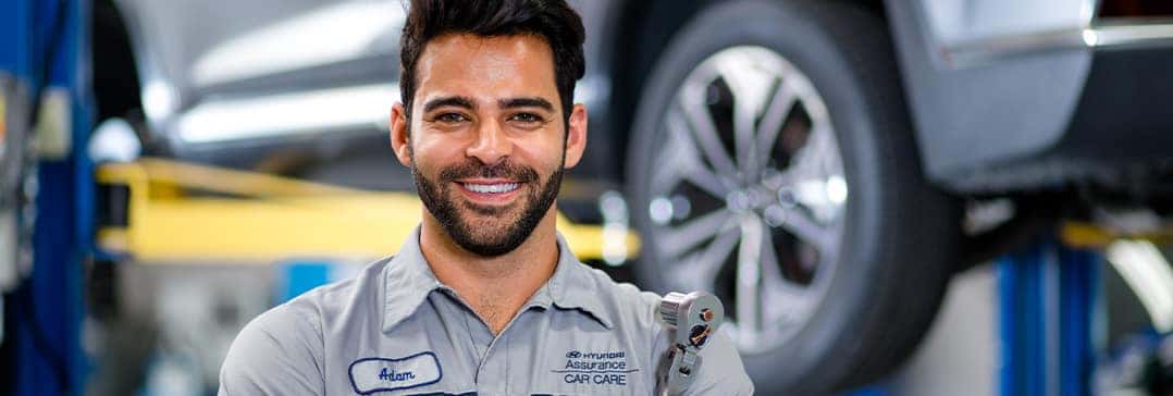 How to check your tires' health at Washington Hyundai of Washington | Mechanic stands confidently with new tire on car