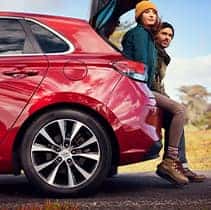 Hyundai Hybrid for Everyone at Washington Hyundai | Two people sitting in the hatch trunk of Elantra