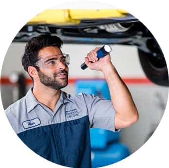 Difference between synthetic oil & conventional oil at Washington Hyundai | Hyundai Technician checks under car's engine bay for issues
