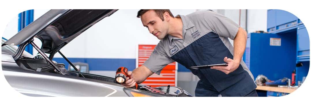 Difference between synthetic oil & conventional oil at Washington Hyundai | Close-up of Hyundai Technician doing a final check under the hood